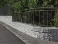 Muro in pietra grigia con ringhiera in ferro battuto, un'ottima idea per muri di recinzione moderni ed eleganti.