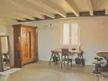 Arredamento casa di campagna: armadio antico in legno, specchio, scrivania rustica con sedia, tavolino rotondo e lampada a forma di Torre Eiffel.
