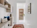 Ingresso accogliente con panca, cuscini e un tappeto persiano. Idee per decorazioni porte interne fai da te ispirate a questo stile.