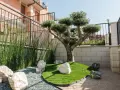 Giardino zen con ulivo bonsai, erba sintetica, pietre bianche e ghiaia. Idee aiuola con ulivo per un angolo di pace.