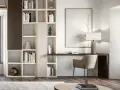 Un piccolo angolo studio in salotto, con libreria componibile, scrivania, sedia e lampada.