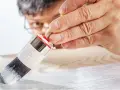 Mano applica primer per mdf con pennello. Preparazione per una finitura perfetta.