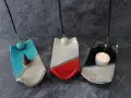 Tre porta incenso fai da te in ceramica, uno blu con cono, uno bianco e rosso, e uno nero con candela accesa.