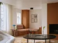 Un elegante soggiorno con un design **art deco interior design**, mobili in legno, un camino e una poltrona soffice.
