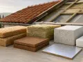 Materiali isolanti per tetti di case di campagna, pronti per l'installazione sotto le tegole rosse.