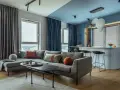 Soggiorno moderno con divano grigio, tavolino nero e tende blu e grigie. Un esempio di come scegliere le tende per il salotto per un look sofisticato.