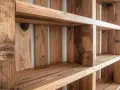 Libreria fai da te in legno grezzo, con ripiani e divisori realizzati con pallet riciclati.