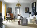 Elegante soggiorno in stile casa art deco con mobili di design, lampadario dorato e opere d'arte astratte.