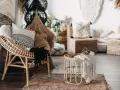 Poltrona in rattan e tavolino con dettagli in macramè, un esempio di design con materiali sostenibili che creano un'atmosfera accogliente.
