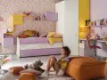 Cameretta bimba con carta da parati a cuori, letto estraibile, scrivania e armadio. Idee colorate e giocose per uno spazio da sogno.