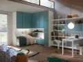 Accogliente camera ragazzo con letto, armadi blu, scrivania e pouf.