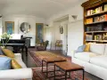 Salotto con pianoforte a coda, divani bianchi, tappeti orientali e libreria. Un perfetto esempio di arredamento classico moderno.