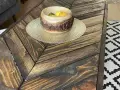 Tavolo con pallet fai da te, con un cesto di frutta in legno e un tappeto geometrico.