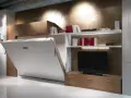 Soluzione salvaspazio per come arredare una casa piccola: letto a scomparsa integrato con libreria e mobile TV.