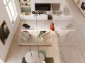 Arredamento soggiorno moderno con divano bianco, tavolino nero, quadro cactus e giradischi.