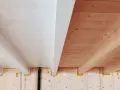 Soffitto perlinato sbiancato con travi a vista in legno naturale. Un contrasto di finiture che crea un ambiente caldo e luminoso.