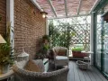 Accogliente veranda piccola con mobili in vimini, piante verdi e un pergolato in bambù. Perfetta per creare un angolo relax.