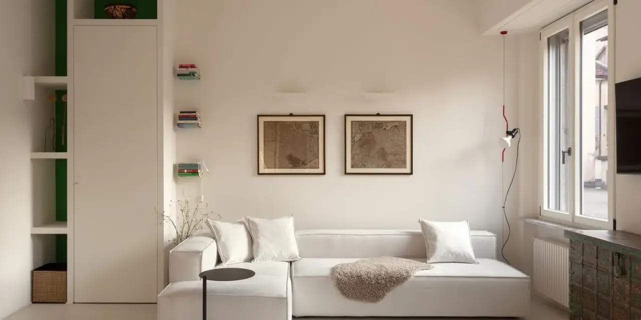 Soggiorno moderno con divano bianco, quadri antichi e un mobile etnico. Idee per case belle da copiare.