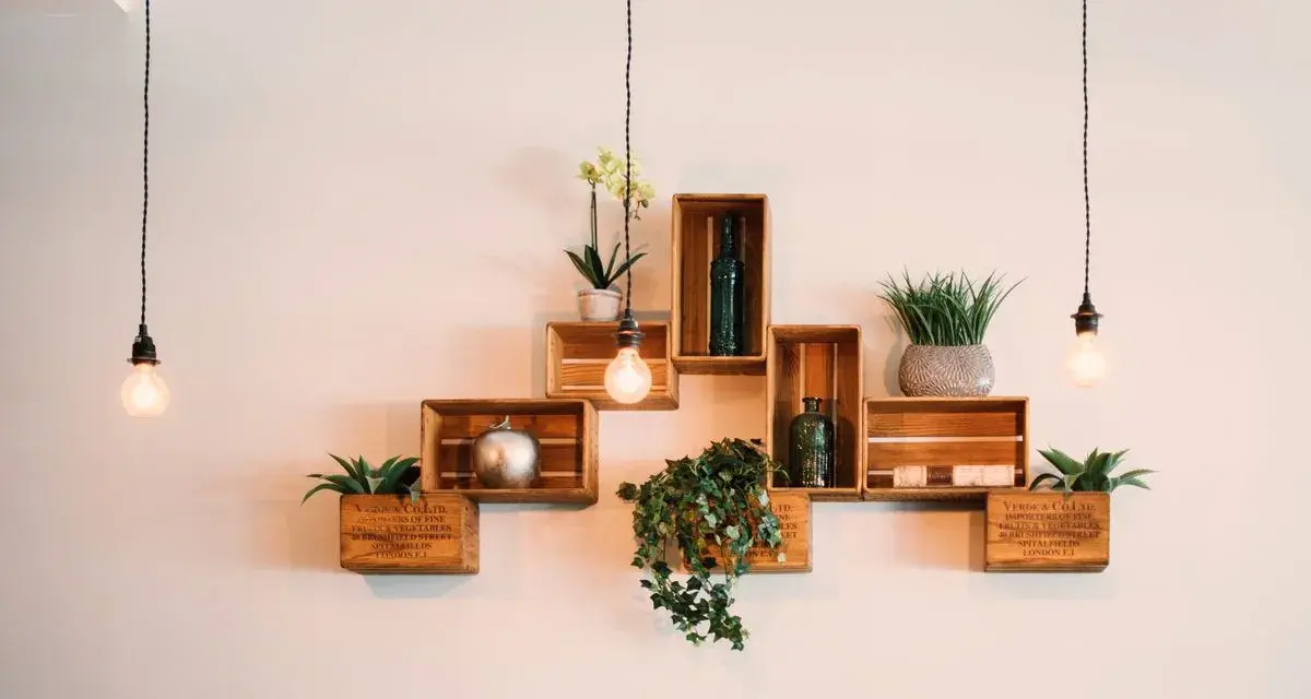 Come posizionare i cubi a muro: una composizione creativa con piante, bottiglie e decorazioni su mensole di legno.