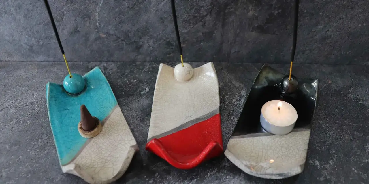 Tre porta incenso fai da te in ceramica, uno blu con cono, uno bianco e rosso, e uno nero con candela accesa.