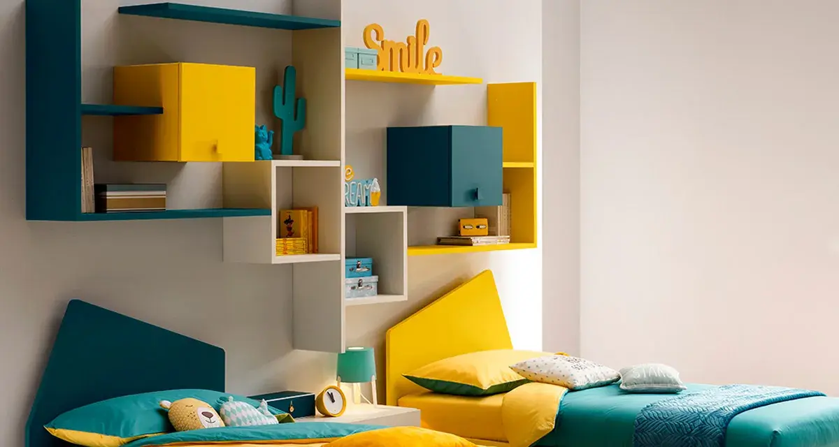 Idee angolo giochi in salotto: due letti colorati, mensole con decorazioni e contenitori, perfetti per una stanza vivace.