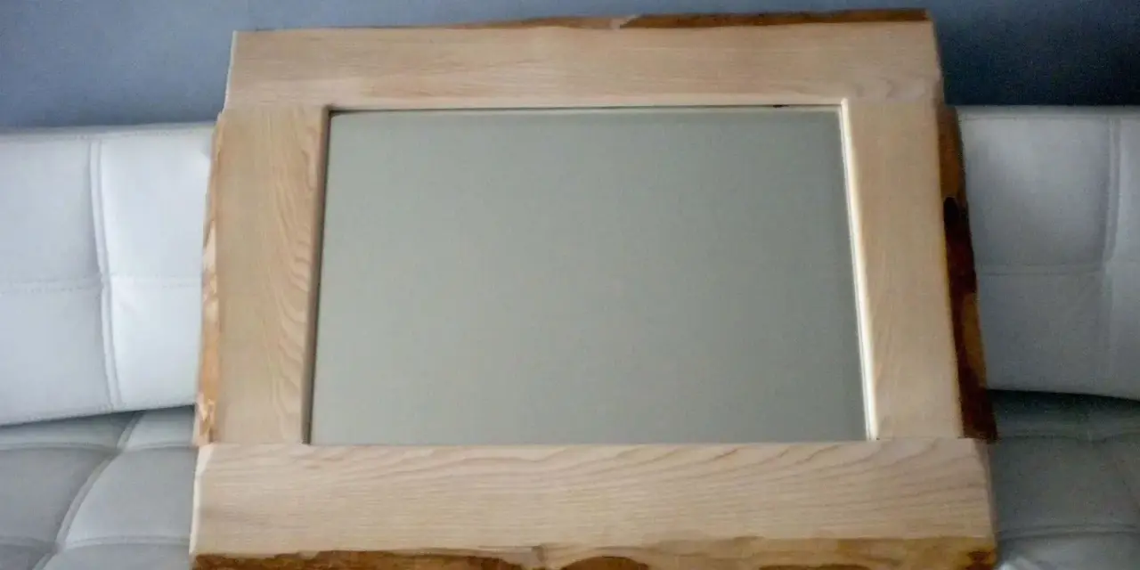 Specchio con cornice in legno grezzo, un'idea per una cornice specchio fai da te rustica e naturale.