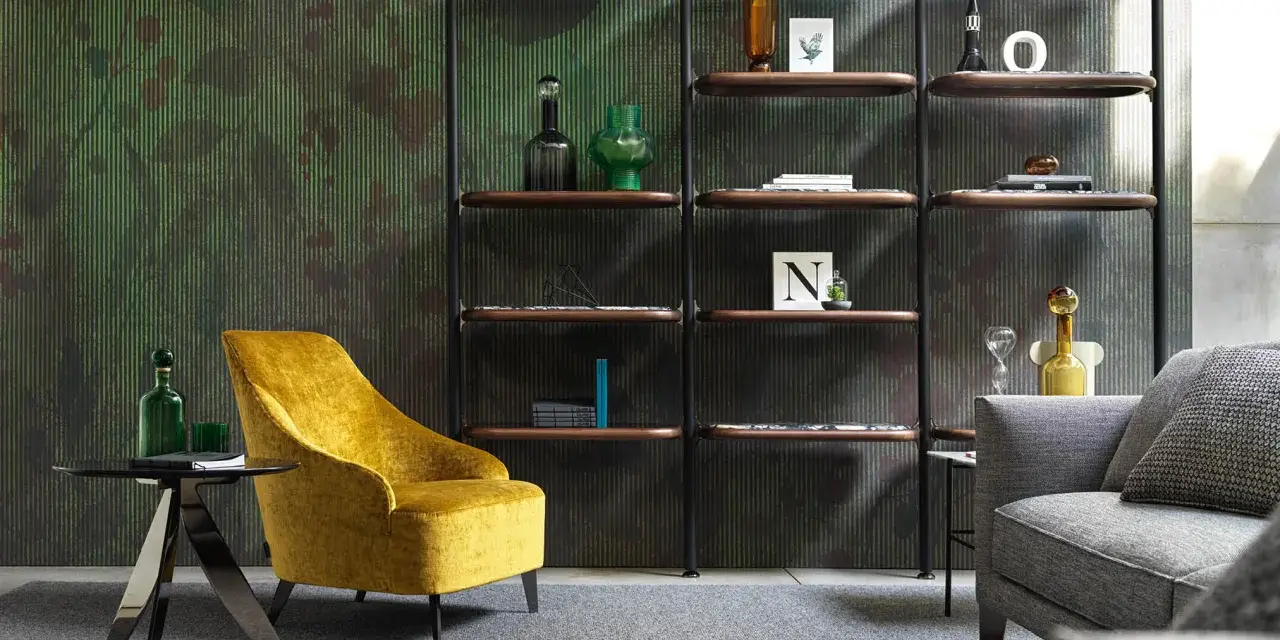 Un comodo angolo lettura con poltrona gialla, tavolino nero e libreria a parete con oggetti decorativi.