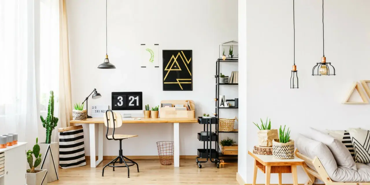 Un moderno angolo studio con scrivania in legno, computer, piante e un divano accogliente.