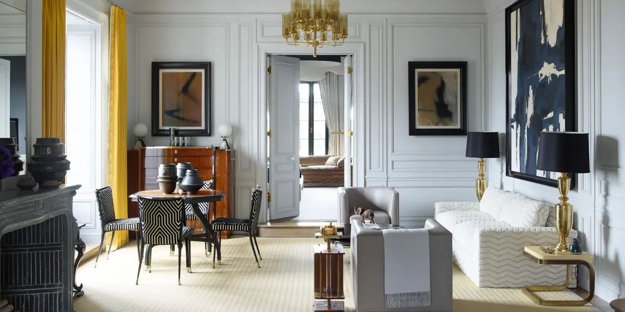 Elegante soggiorno in stile casa art deco con mobili di design, lampadario dorato e opere d'arte astratte.
