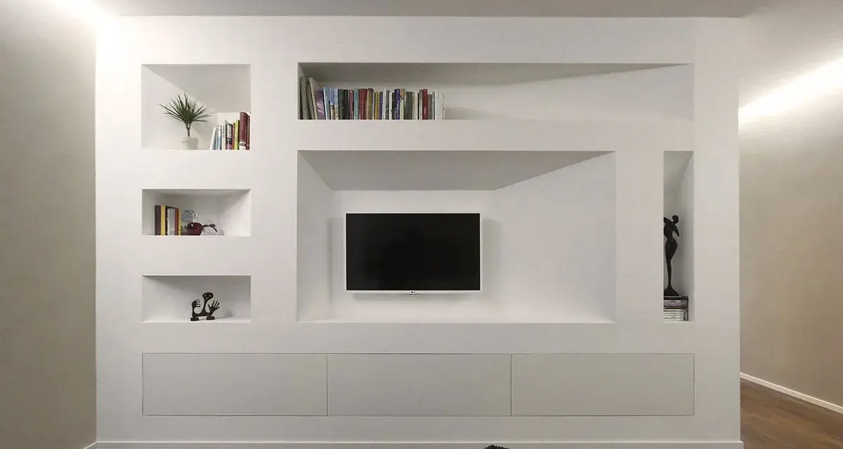 Una moderna parete in cartongesso con nicchie per libri, TV e decorazioni.