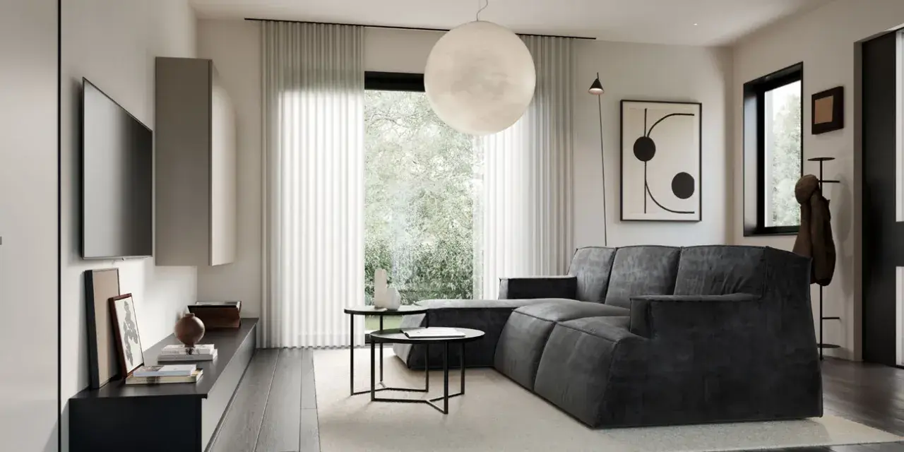 Soggiorno in una casa stile moderno contemporaneo, con divano angolare grigio, tavolini neri, TV a parete e grande lampada sferica.