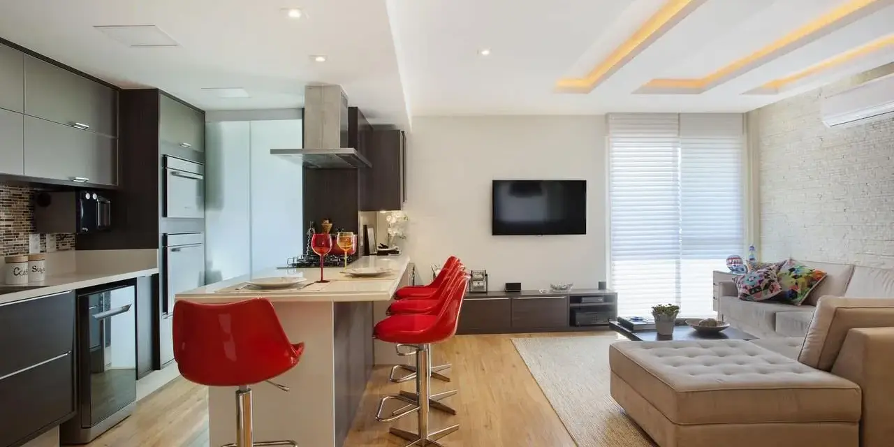 Elegante soggiorno con cucina a vista, illuminato da moderni controsoffitti in cartongesso.