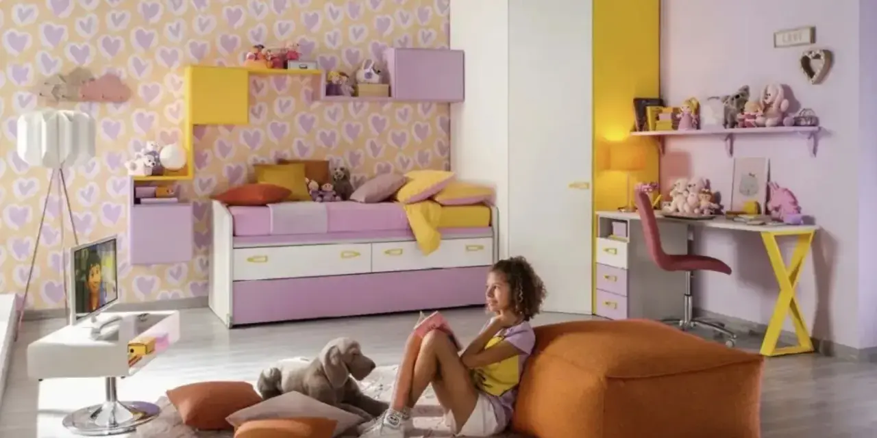 Cameretta bimba con carta da parati a cuori, letto estraibile, scrivania e armadio. Idee colorate e giocose per uno spazio da sogno.
