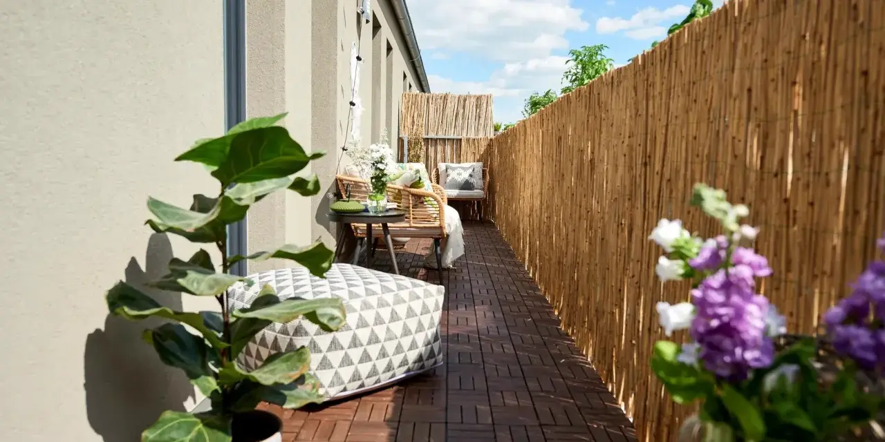 Terrazzo accogliente con mobili in rattan, cuscini decorativi e piante. Le decorazioni terrazzo creano un'oasi di relax.
