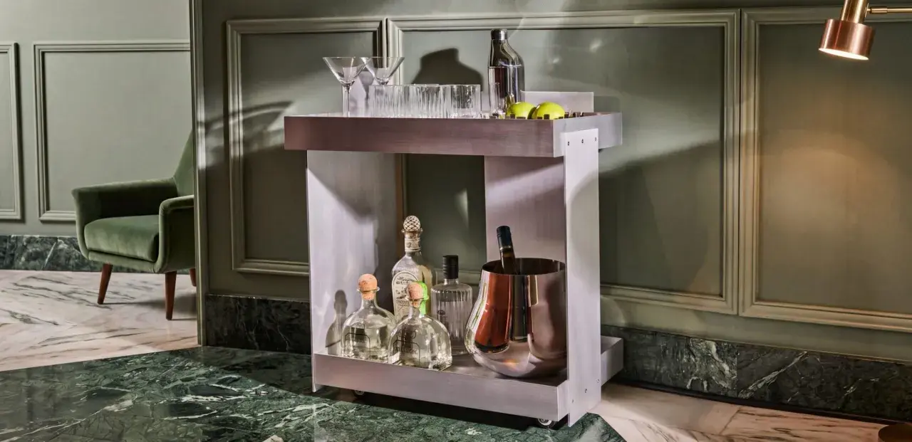 Carrello bar moderno con bottiglie di tequila, bicchieri e secchiello per il ghiaccio. Un'ottima idea per un angolo bar casa elegante.