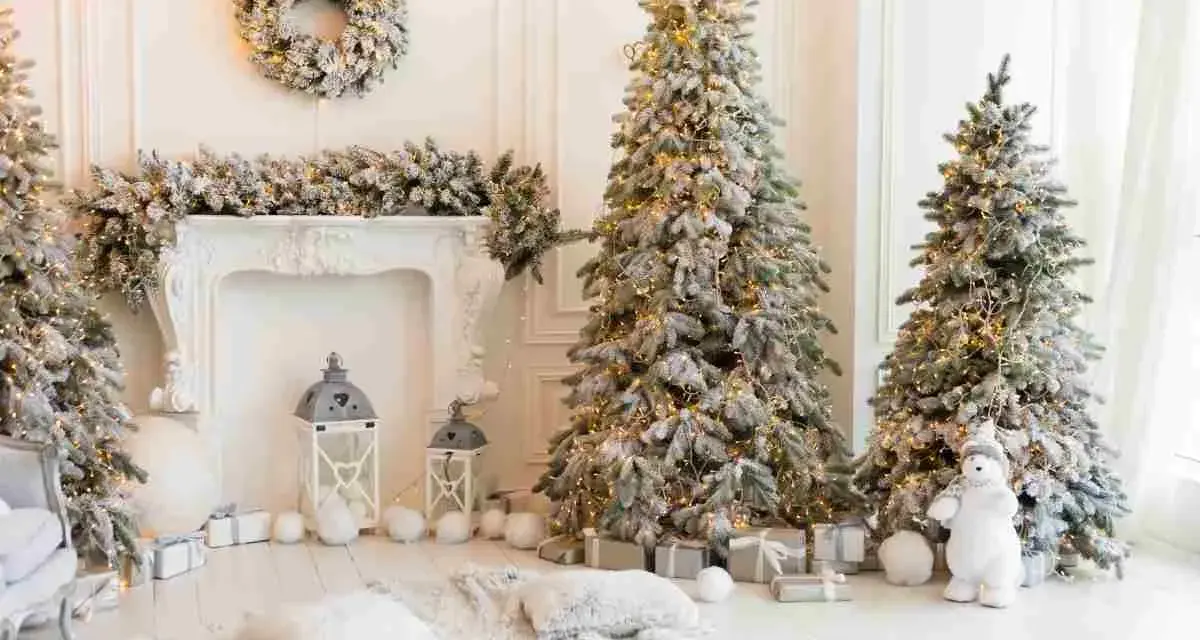 Un incantevole scenario natalizio con alberi innevati, luci calde e regali. Ecco come decorare albero di natale bianco per un'atmosfera magica.