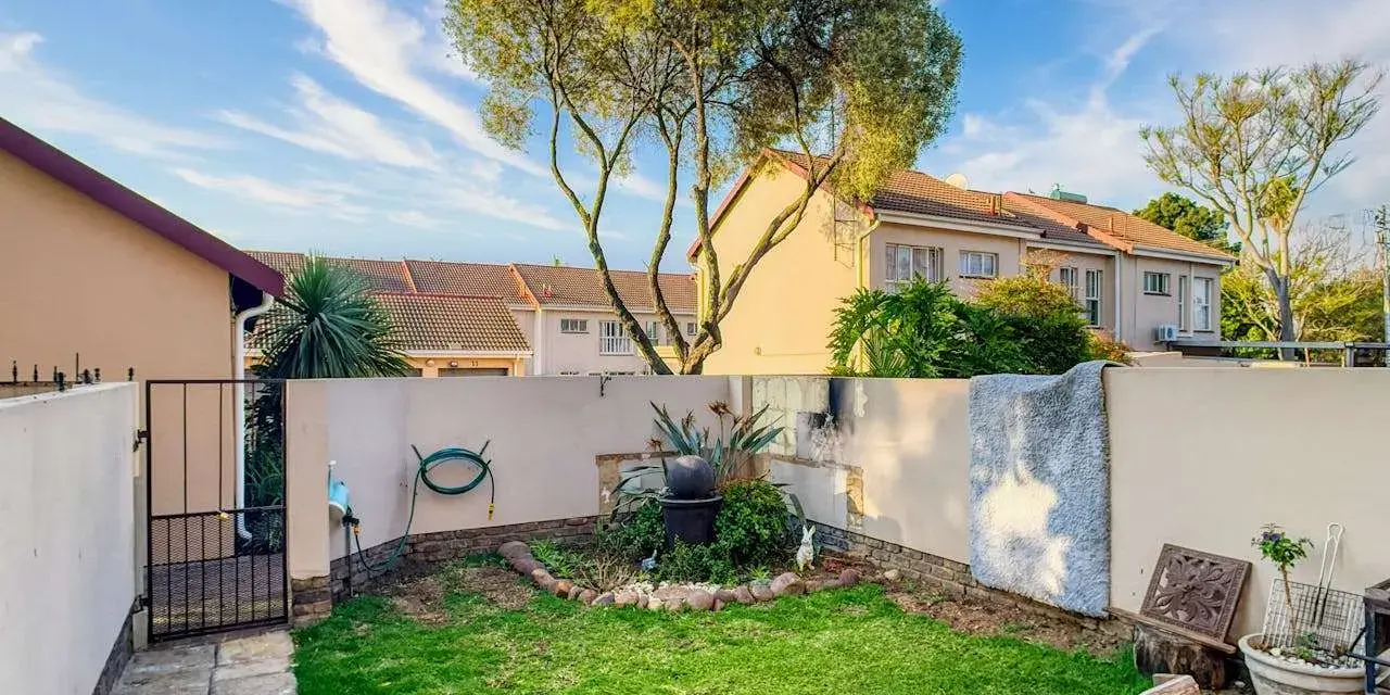Giardino con prato verde, piante e un piccolo laghetto. Idee per come abbellire un giardino con pochi soldi, con mobili riciclati e decorazioni fai-da-te.