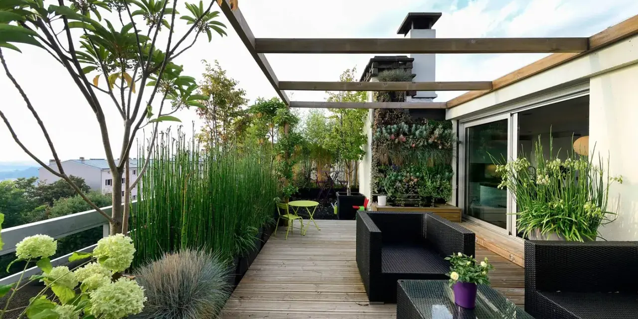 Un terrazzo moderno e accogliente, perfetto per arredare con stile. Mobili in rattan nero, un giardino verticale rigoglioso e piante verdi creano un'oasi urbana.