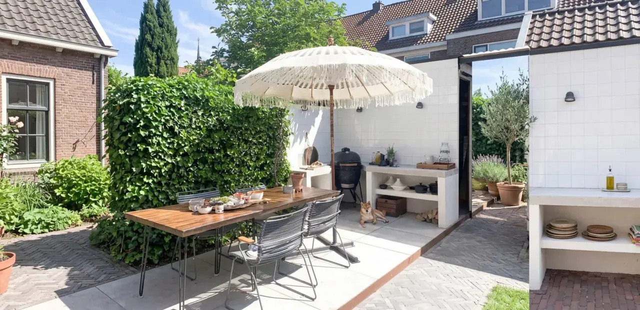 Accogliente zona barbecue esterna con tavolo in legno, sedie, ombrellone e un cane Shiba Inu che si rilassa.