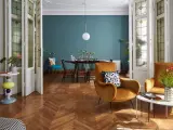 Salotto con poltrone ocra, tavolino dal design moderno e porte a soffietto con vetri decorati, un mix di stile vintage e contemporaneo.