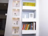 Moderne idee mensole in cartongesso con nicchie illuminate per statuette e ripiani per libri e decorazioni.