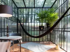 Veranda piccola arredata con amaca, piante e un tavolino. Idee per arredare una veranda piccola con stile e comfort.