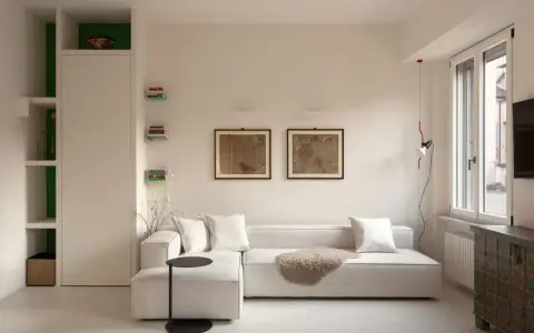 Soggiorno moderno con divano bianco, quadri antichi e un mobile etnico. Idee per case belle da copiare.