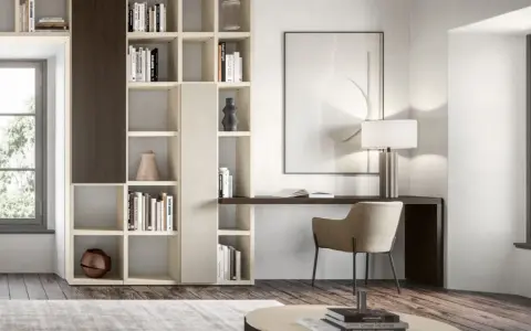 Un piccolo angolo studio in salotto, con libreria componibile, scrivania, sedia e lampada.