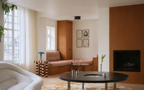Un elegante soggiorno con un design **art deco interior design**, mobili in legno, un camino e una poltrona soffice.