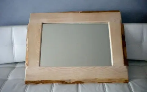 Specchio con cornice in legno grezzo, un'idea per una cornice specchio fai da te rustica e naturale.