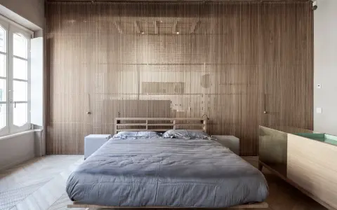 Camerette con separè in legno che creano un ambiente caldo e moderno. Letto matrimoniale con biancheria grigia e comodini bianchi.