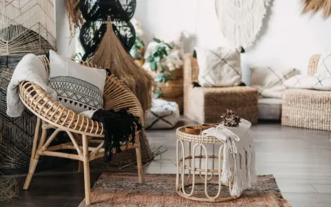 Poltrona in rattan e tavolino con dettagli in macramè, un esempio di design con materiali sostenibili che creano un'atmosfera accogliente.