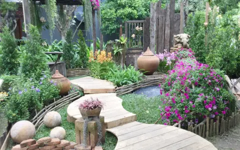 Percorso sinuoso in legno tra fiori vivaci e vasi in terracotta, con elementi decorativi che evocano idee giardino zen.