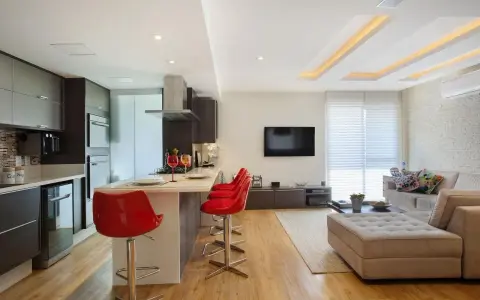 Elegante soggiorno con cucina a vista, illuminato da moderni controsoffitti in cartongesso.